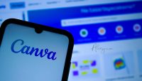 Logo de Canva en un teléfono móvil con la página web de Canva desenfocada de fondo; crea logos con IA y sitios web sin código.