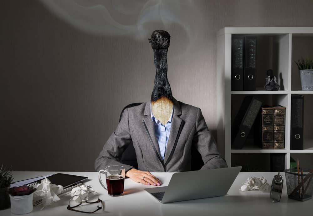 Persona con cabeza de cerilla quemada, que ilustra el síndrome de burnout definición.
